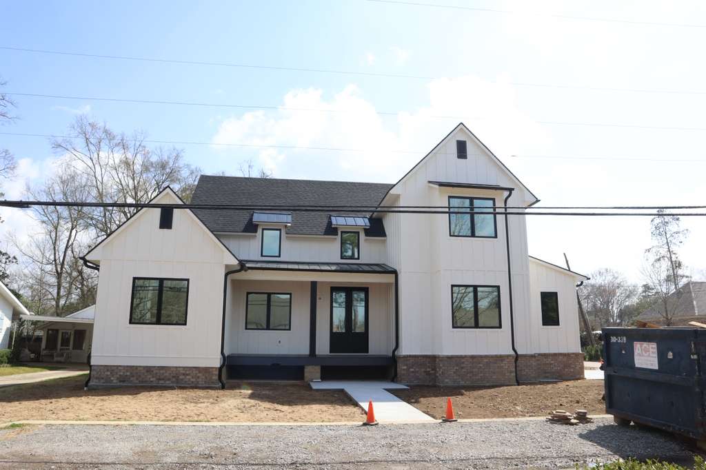 Two-story modern farmhouse with black-frame tinted windows